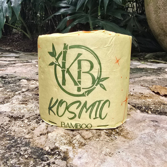 Kosmic Bamboo product on a stone surface with green foliage in the background